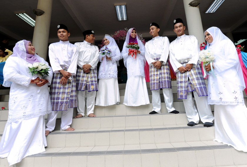 Picture released October 26, 2014 shows newly-wed couples posing for the camera outside the mosque after performing their Nikah vows during the Mau00e2u20acu2122al Hijrah celebration at Masjid Al-Khairiyah, Kuala Lumpur yesterday. u00e2u20acu201d Bernama pic