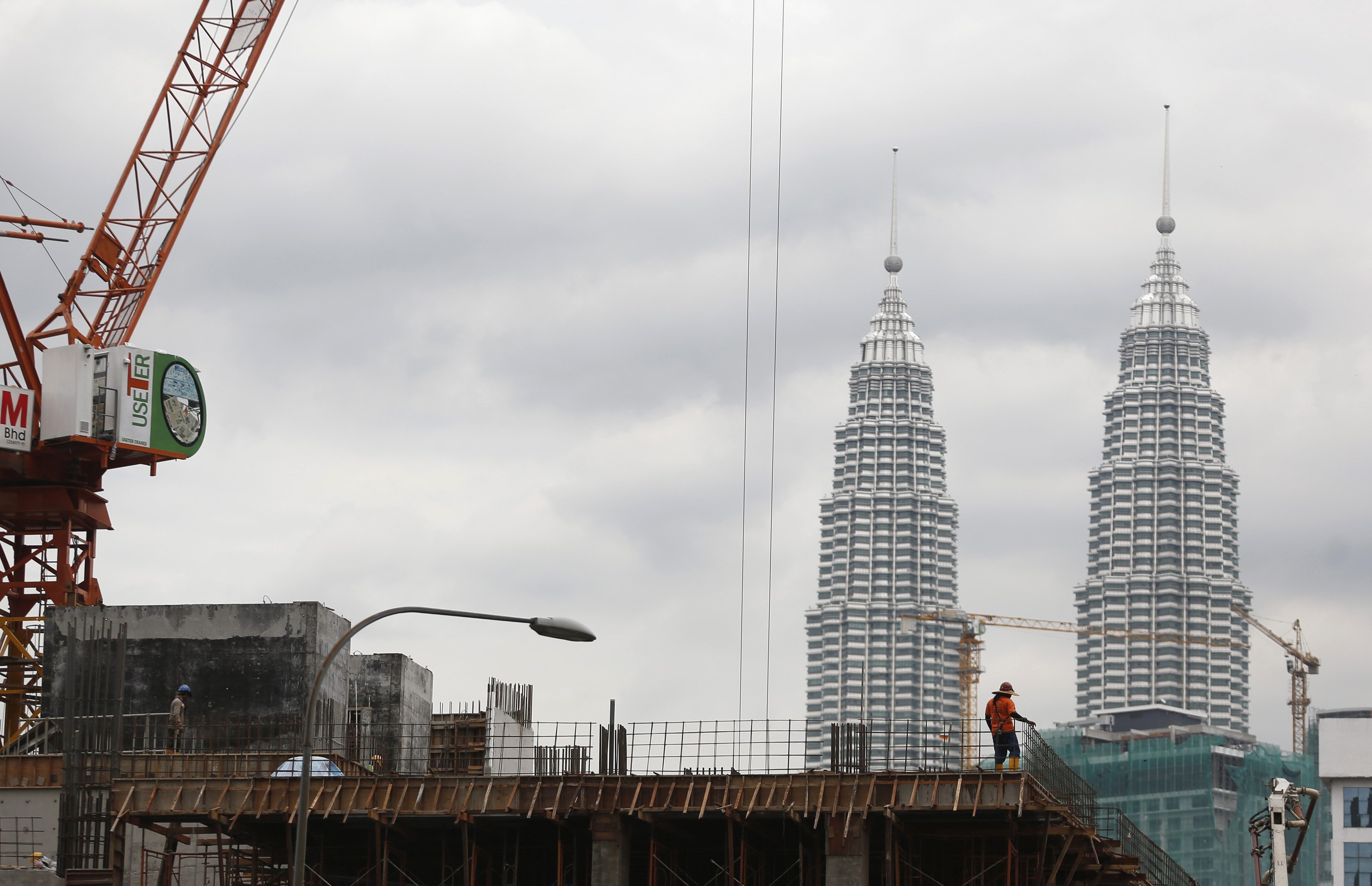 A worker is seen at a construction site, with the Malaysia's landmark Petronas Twin Towers in the background, in Kuala Lumpur September 12, 2013. u00e2u20acu201c Reuters pic