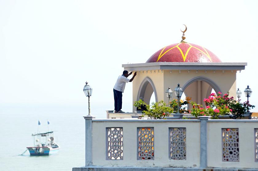 A mosque helper carries out some maintenance work on the Tanjung Bungah floating mosque in George Town February 12, 2014. u00e2u20acu201d Picture by KE Ooi