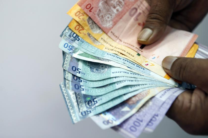 An employee counts money as he poses inside a money exchange centre in Kuala Lumpur October 22, 2013. u00e2u20acu201du00c2u00a0Reuters pic