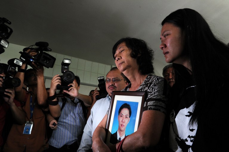 Teoh Beng Hocku00e2u20acu2122s mother Teng Shuw Hor (centre) and sister Teoh Lee Lan (right) react as they leave the Shah Alam Criminal court while holding Teohu00e2u20acu2122s portrait in the outskirts of Kuala Lumpur on January 5, 2011. u00e2u20acu201d AFP pic