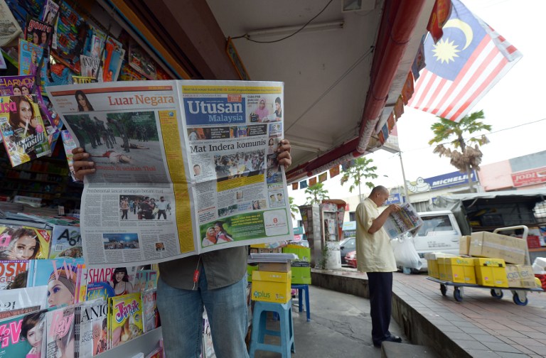 A Malaysian man reads a newspaper outside a shop in downtown Kuala Lumpur on October 10, 2012. u00e2u20acu201d AFP pic